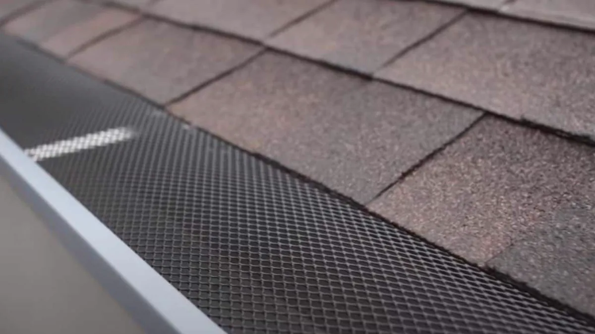 Stainless steel micro-mesh gutter guard installed along a shingle roof